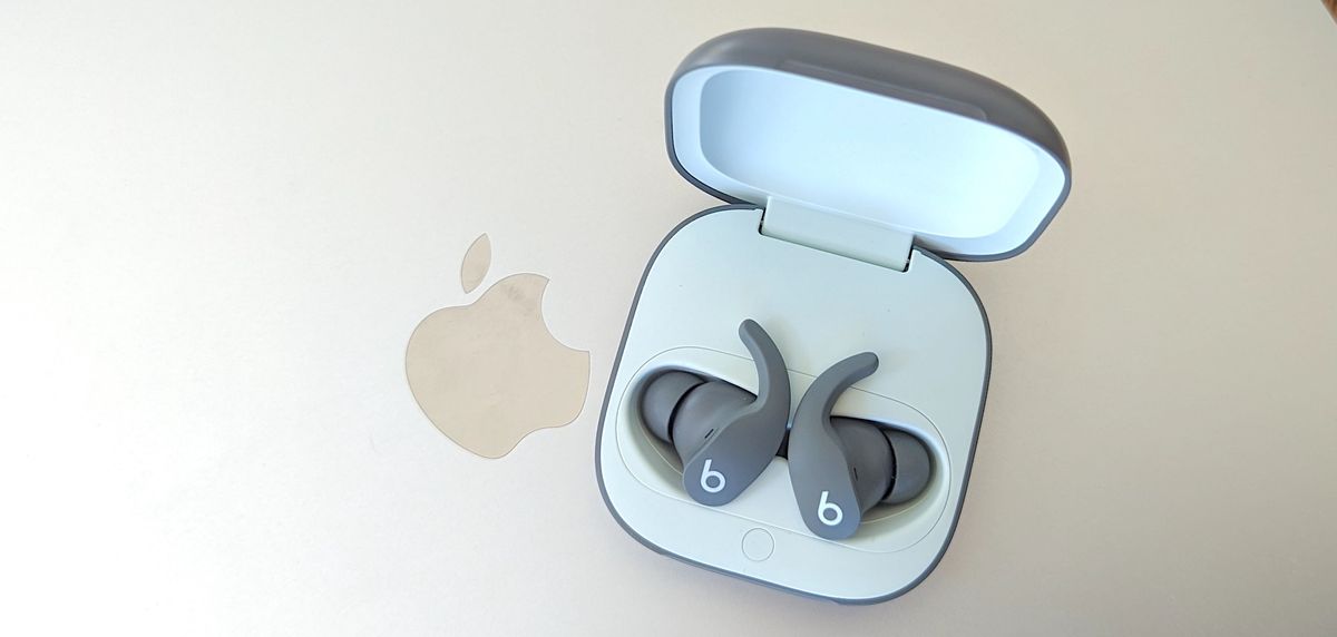 The Beats Fit Pro wireless earbuds rested atop a MacBook Pro