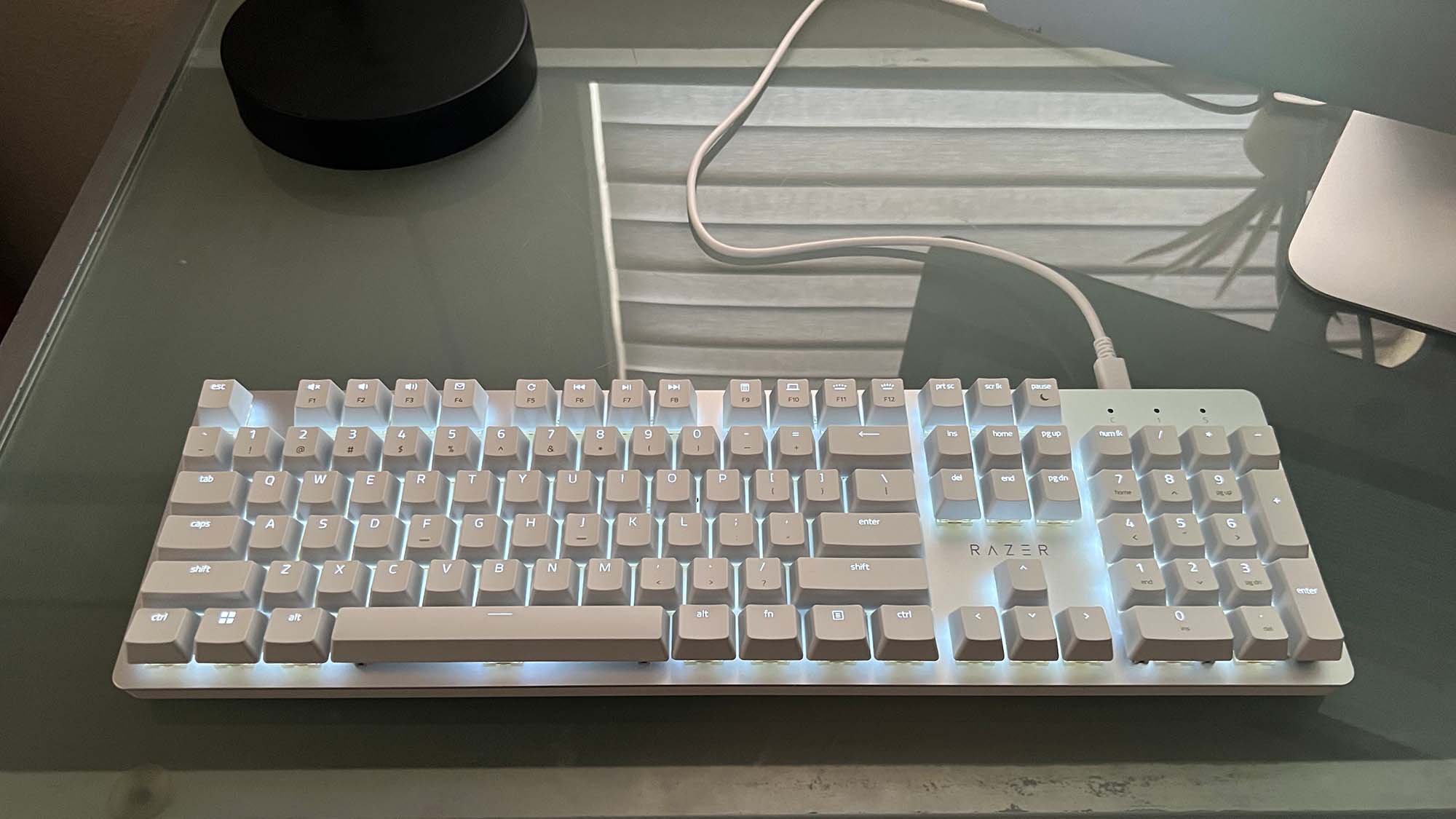 A Razer Pro Type Ultra on a glass-top desk