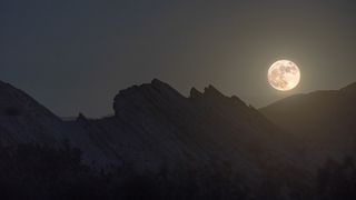 A full moon is visible over Vasquez Rocks Natural Area Park in Santa Clarita, California in 2021.