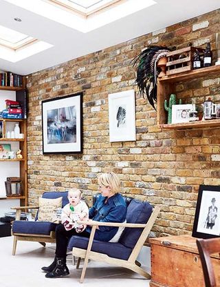 mel walker and otis sitting infront of a stripped back brick wall in industrial kitchen extension