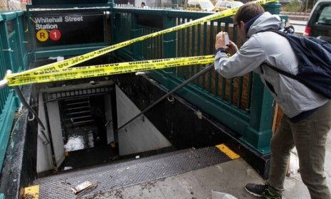 A man takes a photo of a closed and flooded subway station in lower Manhattan on Oct. 30: All seven subway tunnels took in water during the storm. 