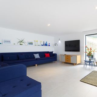 living room with white walls and blue sofa