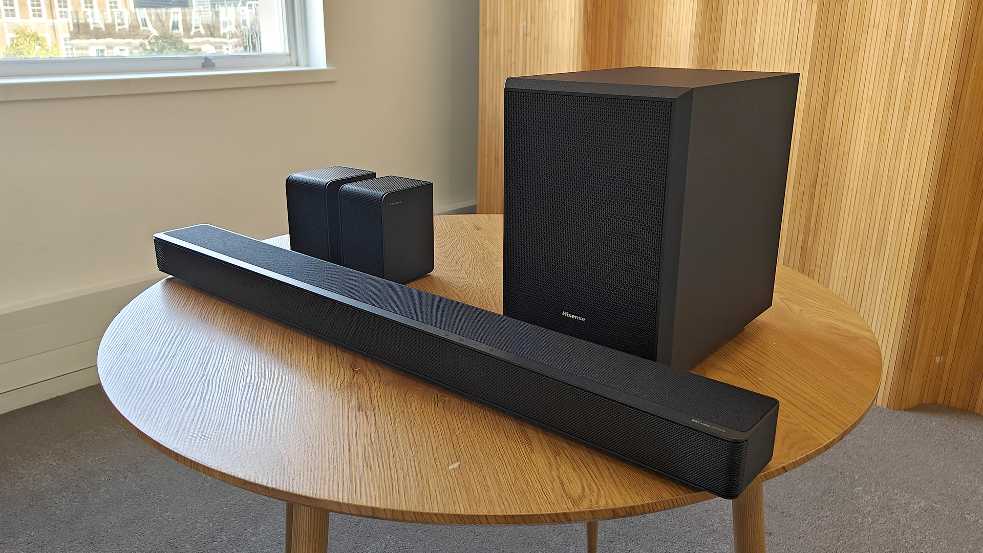 The Hisense AX5125H Dolby Atmos soundbar system, pictured on a round, wooden table