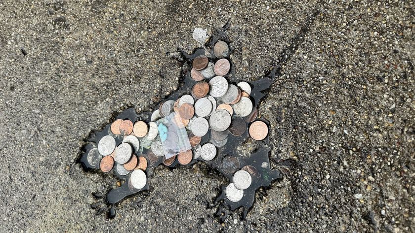 a rat-shaped indentation in a street filled with coins and a baggy of estrogen pills