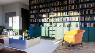 Modern European dining/ living space with a library wall covered with books