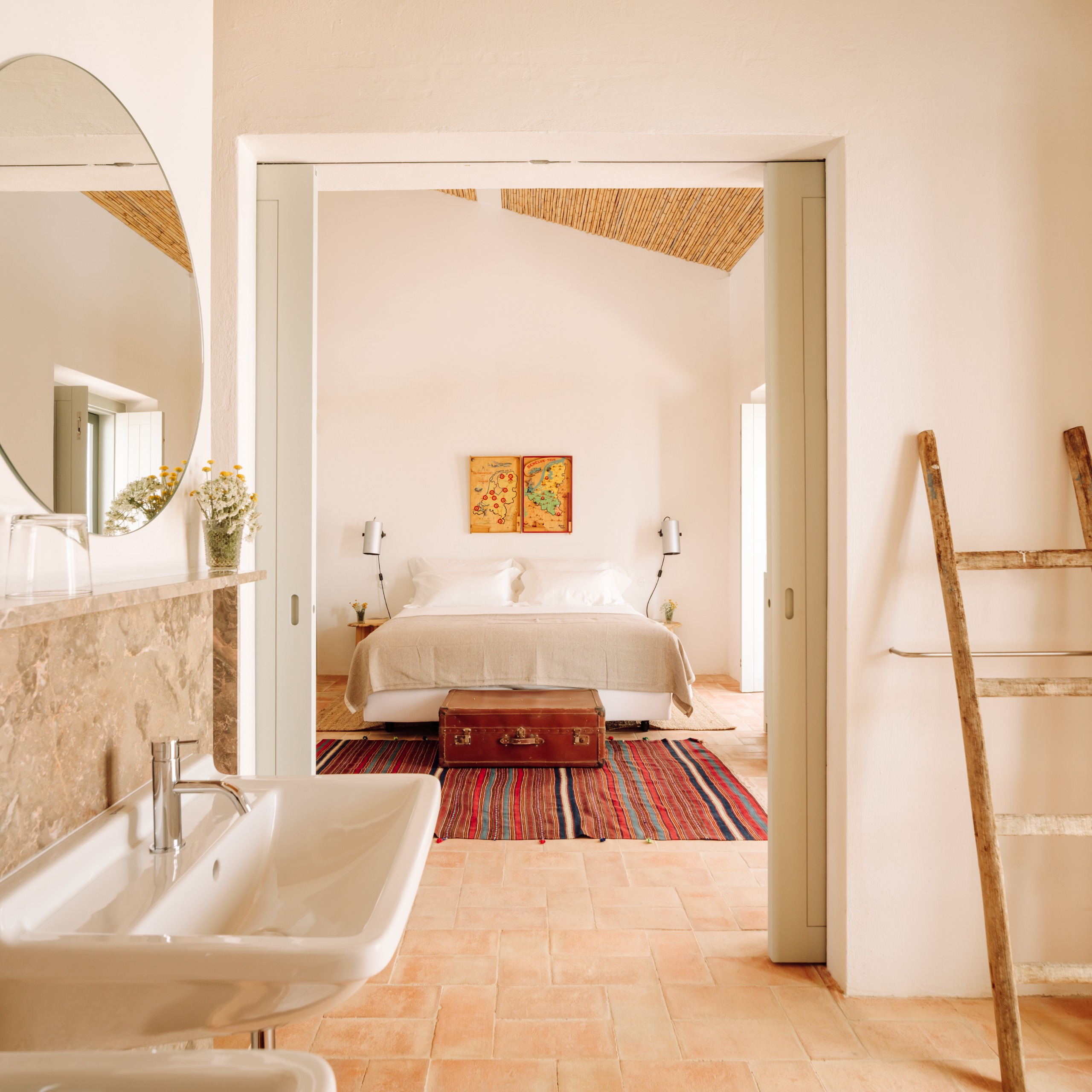 Hotel bedroom with white walls, a cane and plaster ceiling and terracotta brick floor