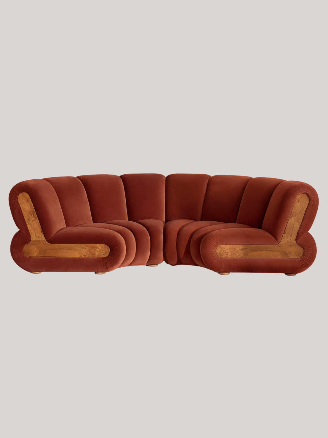 A rust velvet modular curved sofa from Soho Home with a burl wood accent