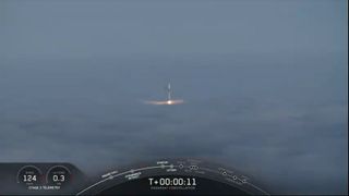 A SpaceX Falcon 9 rocket carrying three Canadian Radarsat Earth-observation satellites emerges above thick fog as it launches into orbit from Vandenberg Air Force in California on June 12, 2019.