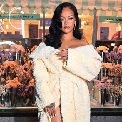 Rihanna wearing a curled side part hairstyle and a textured jacket as a dress.
