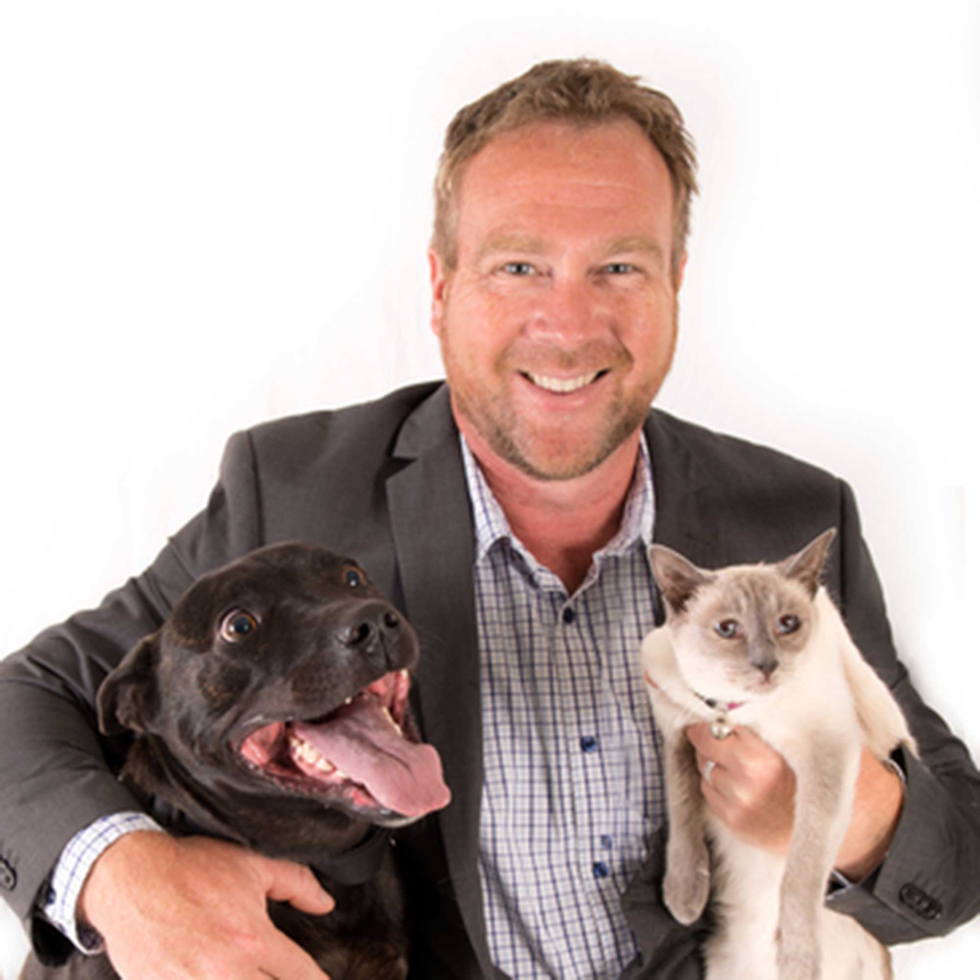 headshot Mark James of PetKeener holding a dog and a cat on a white background