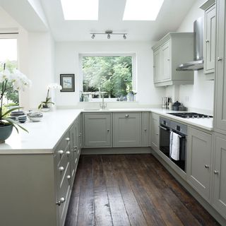 kitchen with wooden floorboard kitchen cabinet and white wall