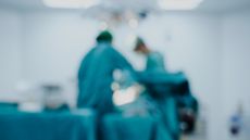 Blurred image of two surgeons operating on someone in an operating theater