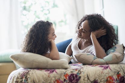 Woman walking about periods with her daughter at home, on the sofa