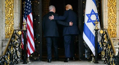 Donald Trump and Benjamin Netanyahu walk inside the Mar-a-Lago residence in Palm Beach, Florida