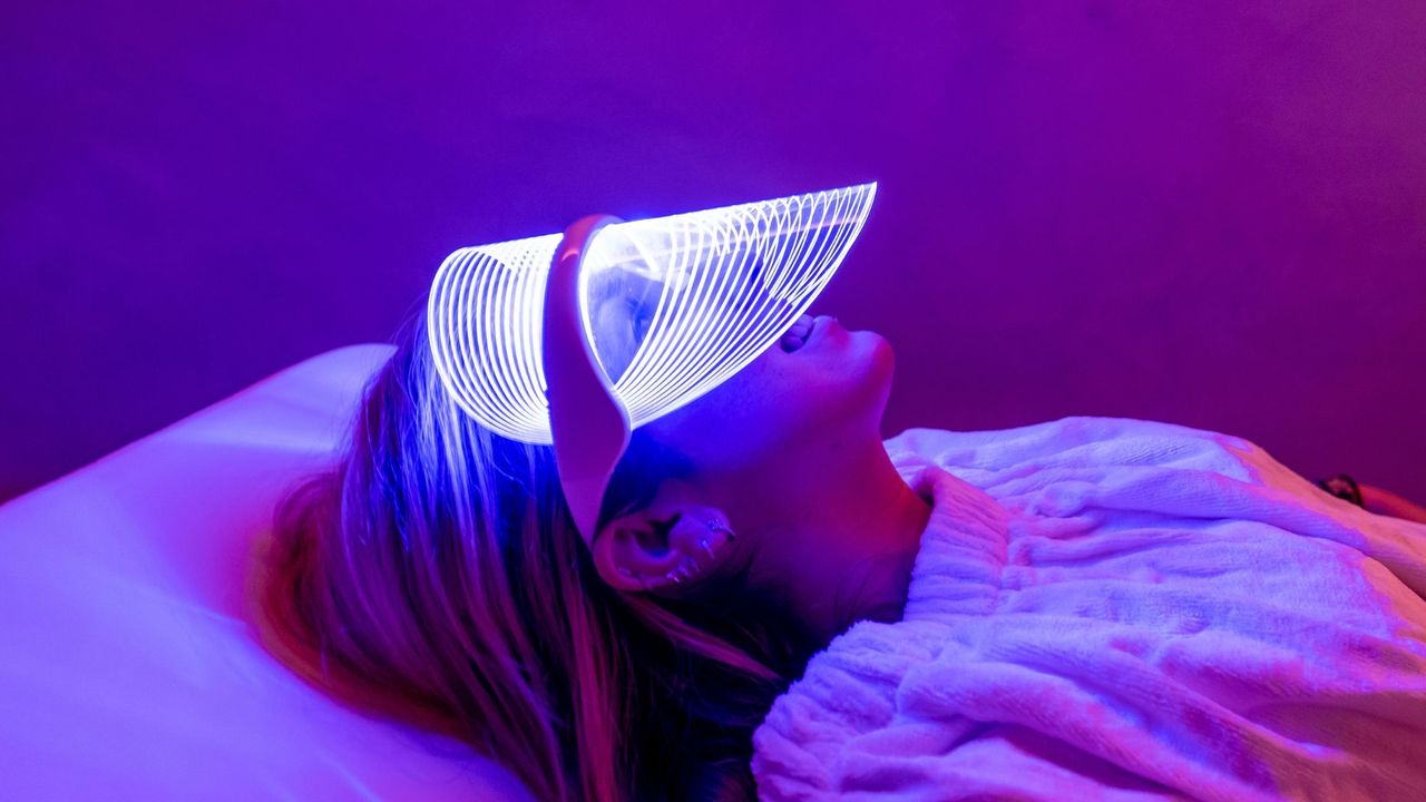 woman lying down using an led face mask