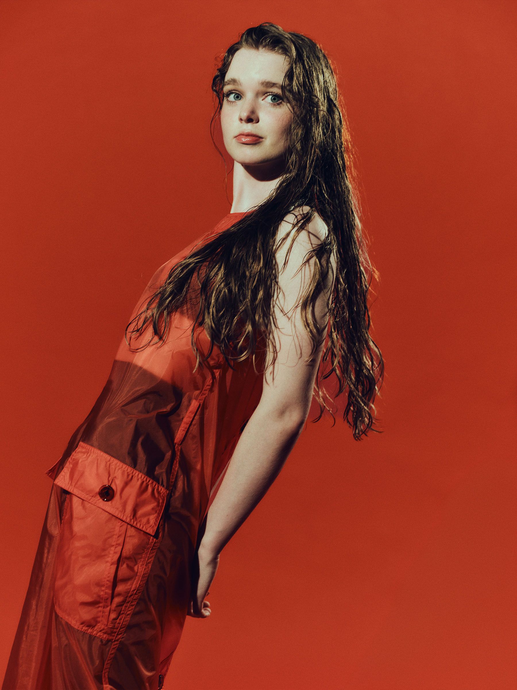 Carrie actress Summer Howell photographed by Jonny Marlow. She is leaning back, wearing a red sheer dress with pockets.