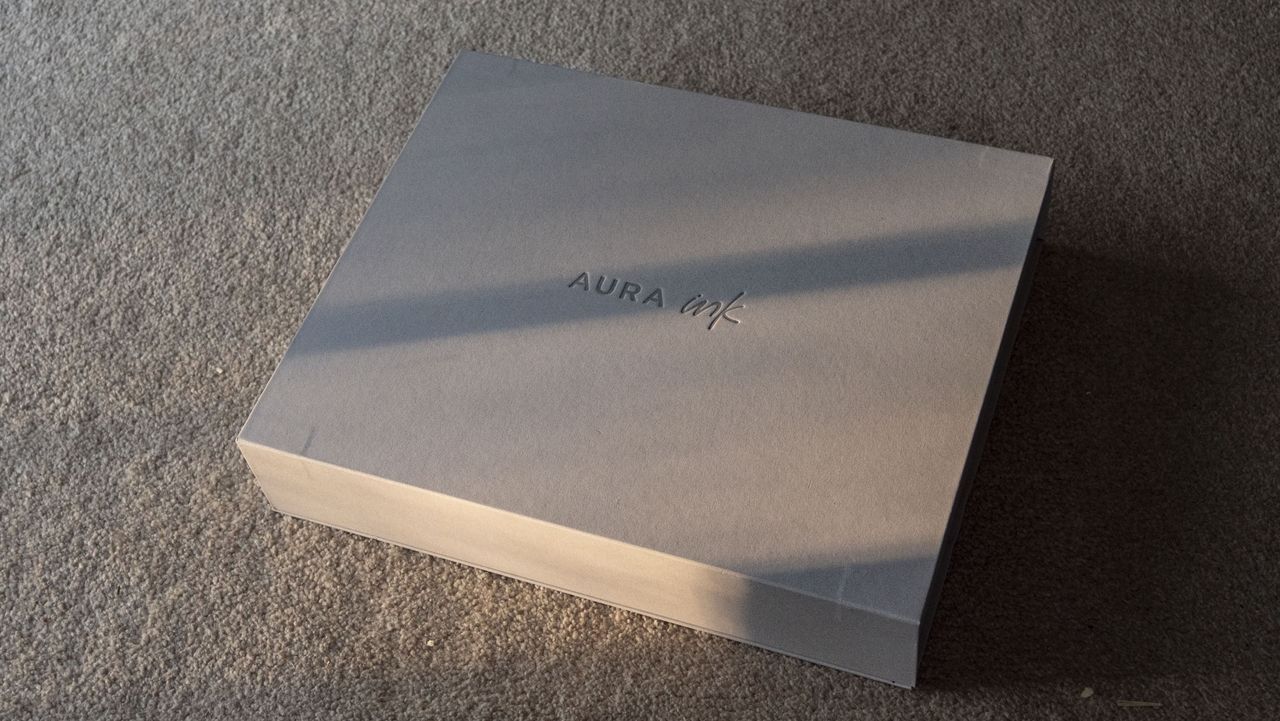 The Aura Ink 'E Ink' digital photo frame's presentation box, illuminated by the golden hour sun
