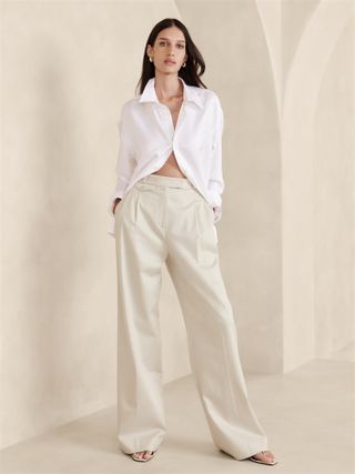 Model wears Banana Republic Pleated Trousers in a creamy off white