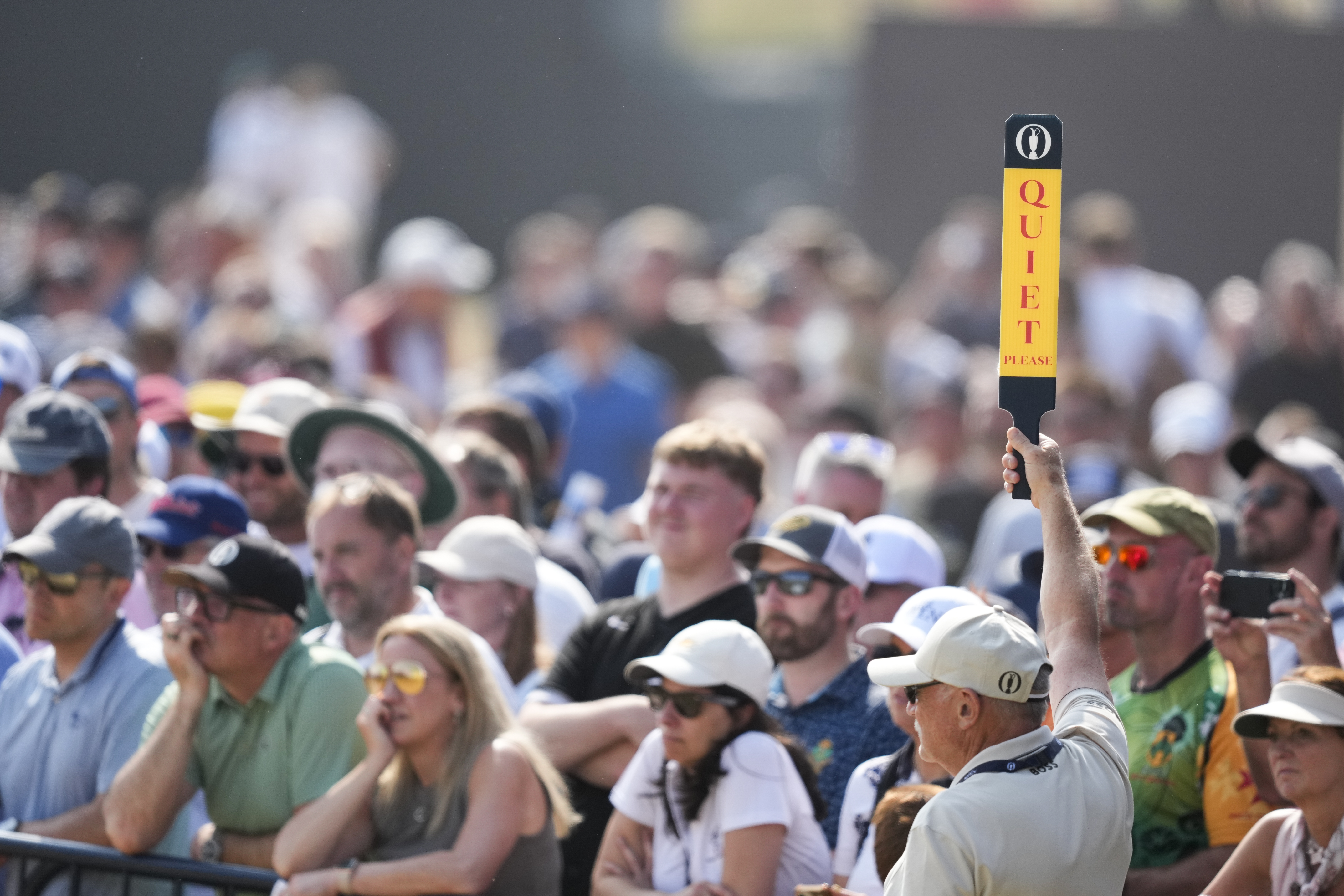 A volunteer holds up a Quiet Please sign at The Open