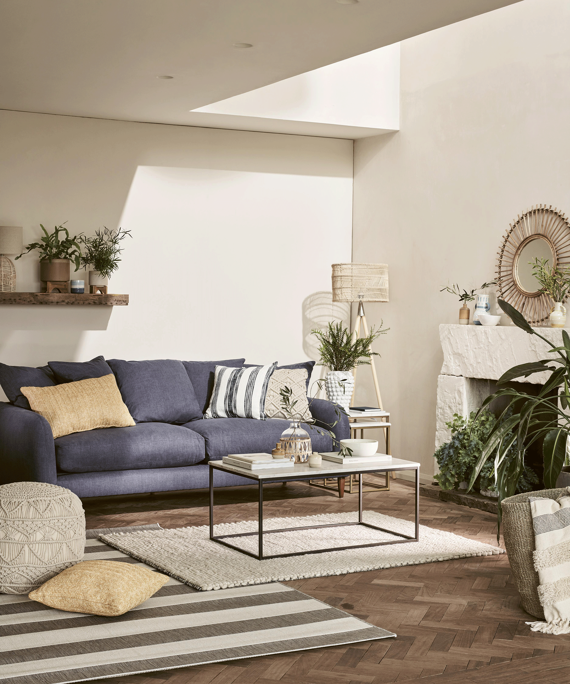 Coastal style living room with denim blue sofa, coffee table and two area rugs layered over each other