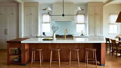 kitchen island with wooden face and white Neolith countertops and bar stools
