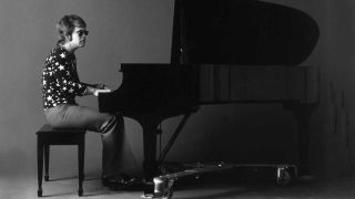 Elton John seated at a grand piano