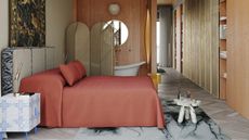 modern bedroom with terracotta-colored sheets, patterned rug, timber wardrobe cabinetry, marble side table at foot of bed, blue and white tiled side table, tapestry hanging above bed, room divider next to freestanding bath tub