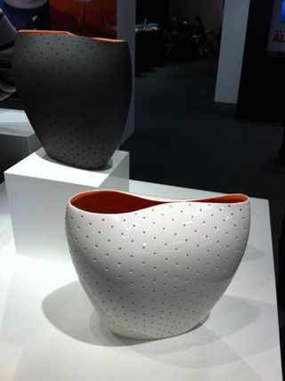 A white and black vase, both with an odd shape and red interior.