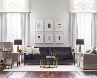 A dark gray velvet sofa in a panelled drawing room