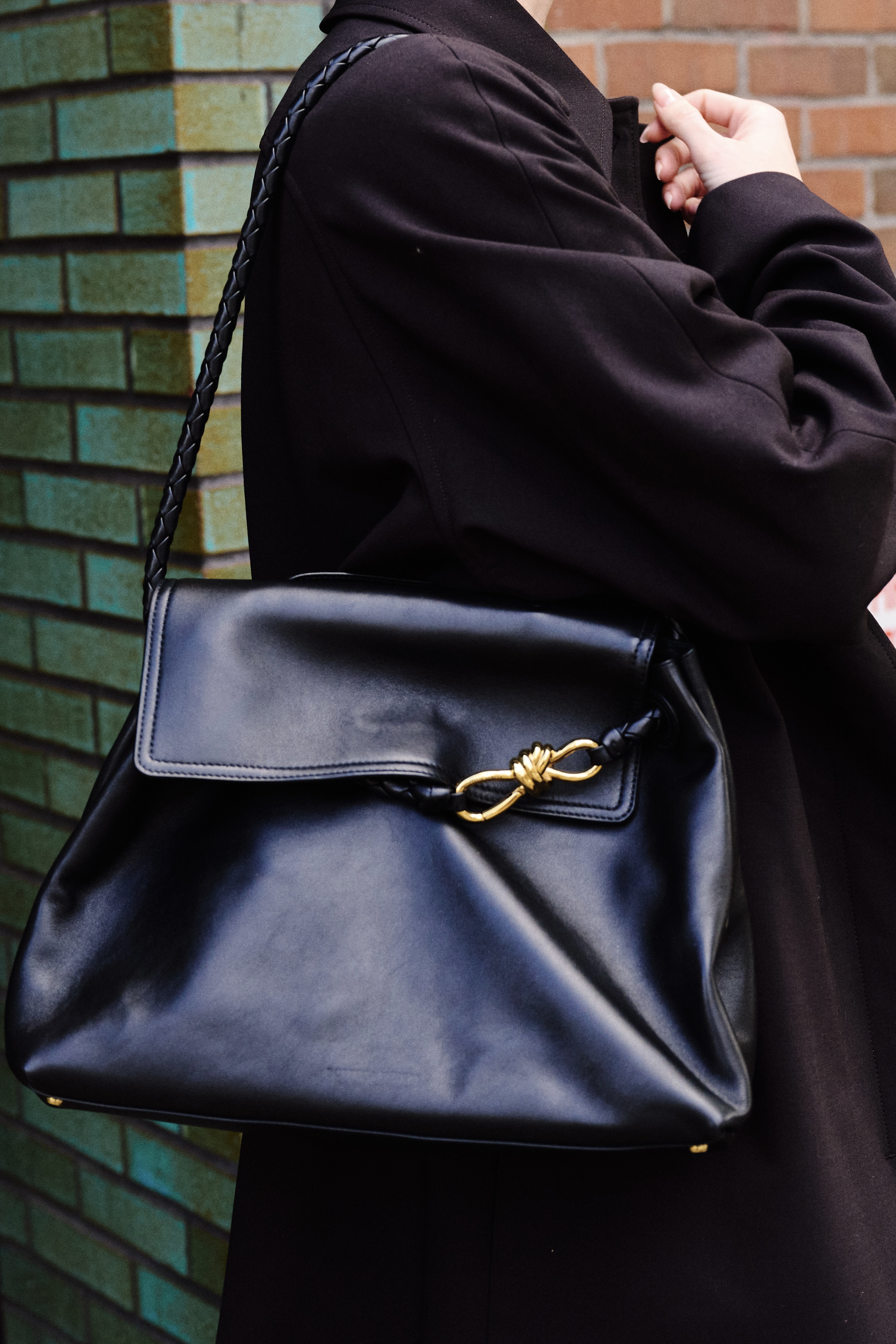 A close-up of Eliza Huber carrying a black Bottega Veneta Ciao Ciao bag outside of the Bowery hotel.