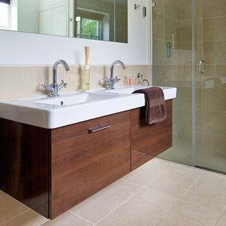 bathroom with white wall wooden cabinet white wash basin cream colour floor