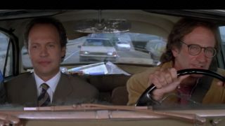 Robin Williams driving a car and Billy Crystal riding with him