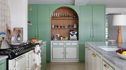 a kitchen with green full length cabinets and white perimeter cabinets with a green border