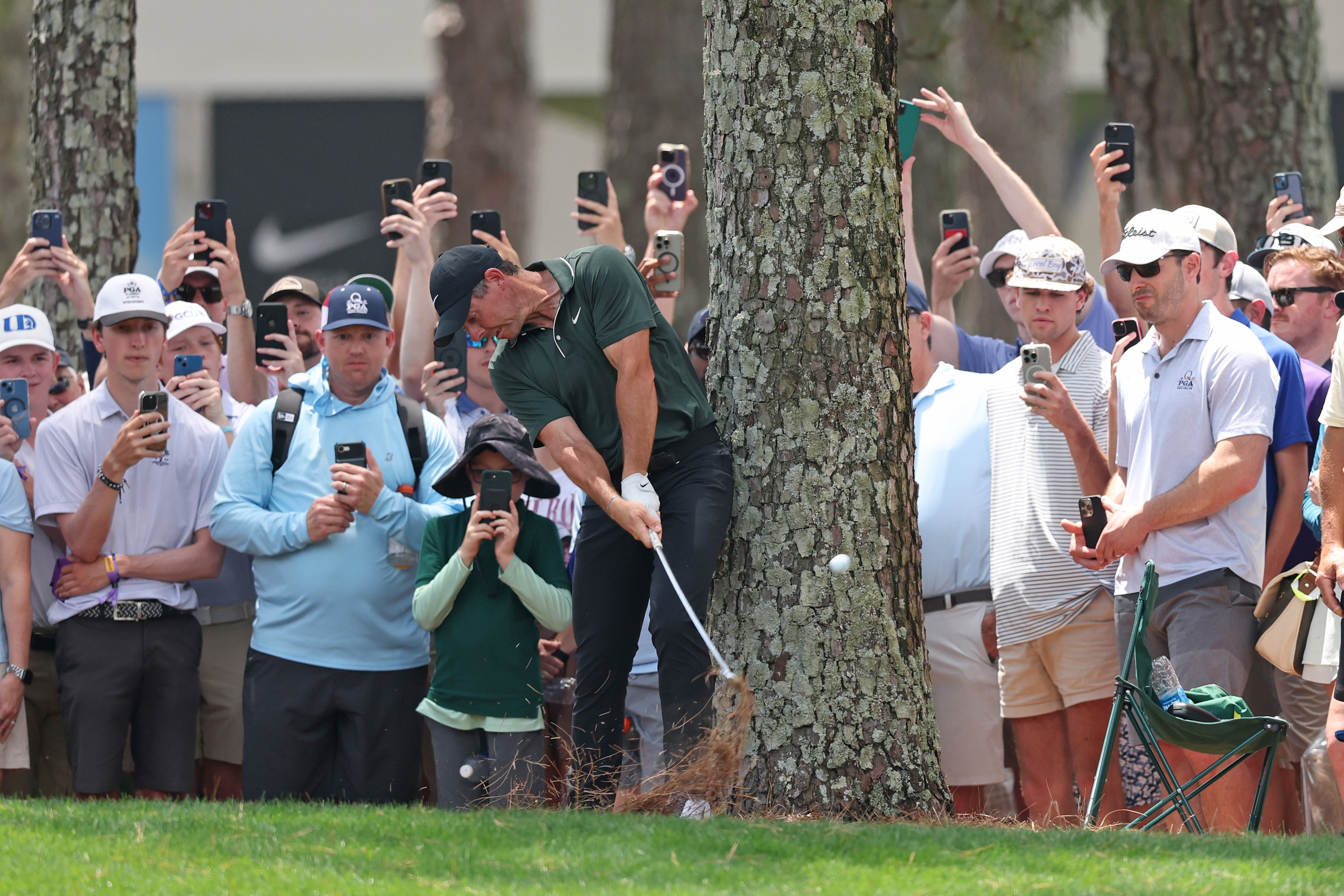 Rory McIlroy hits a shot from behind a tree