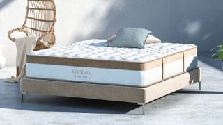 The Saatva Classic luxury innerspring hybrid on a beige colored fabric bed base