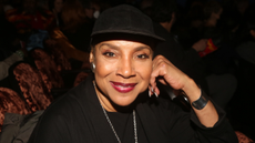 phylicia rashad in a black hat with red lipstick
