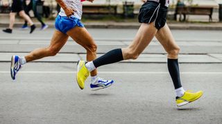 A close-up of two runners’s legs