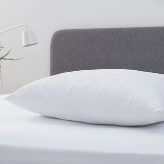 A pillow laid on an upholstered bed
