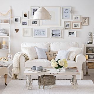white wall with photo frame on wall and sofa with cushions