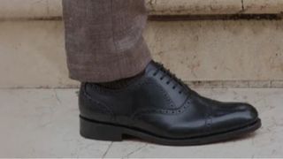 A mans brogue and suit trousers
