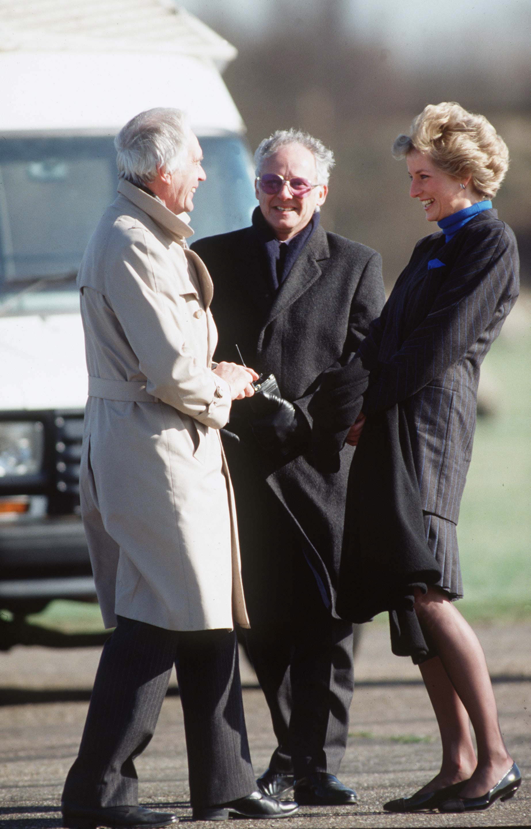 Princess Diana and Dickie Arbiter standing outside in coats and laughing