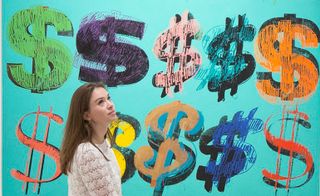 A women standing in front of Andy Warhol, Dollar Signs, 1981 artwork