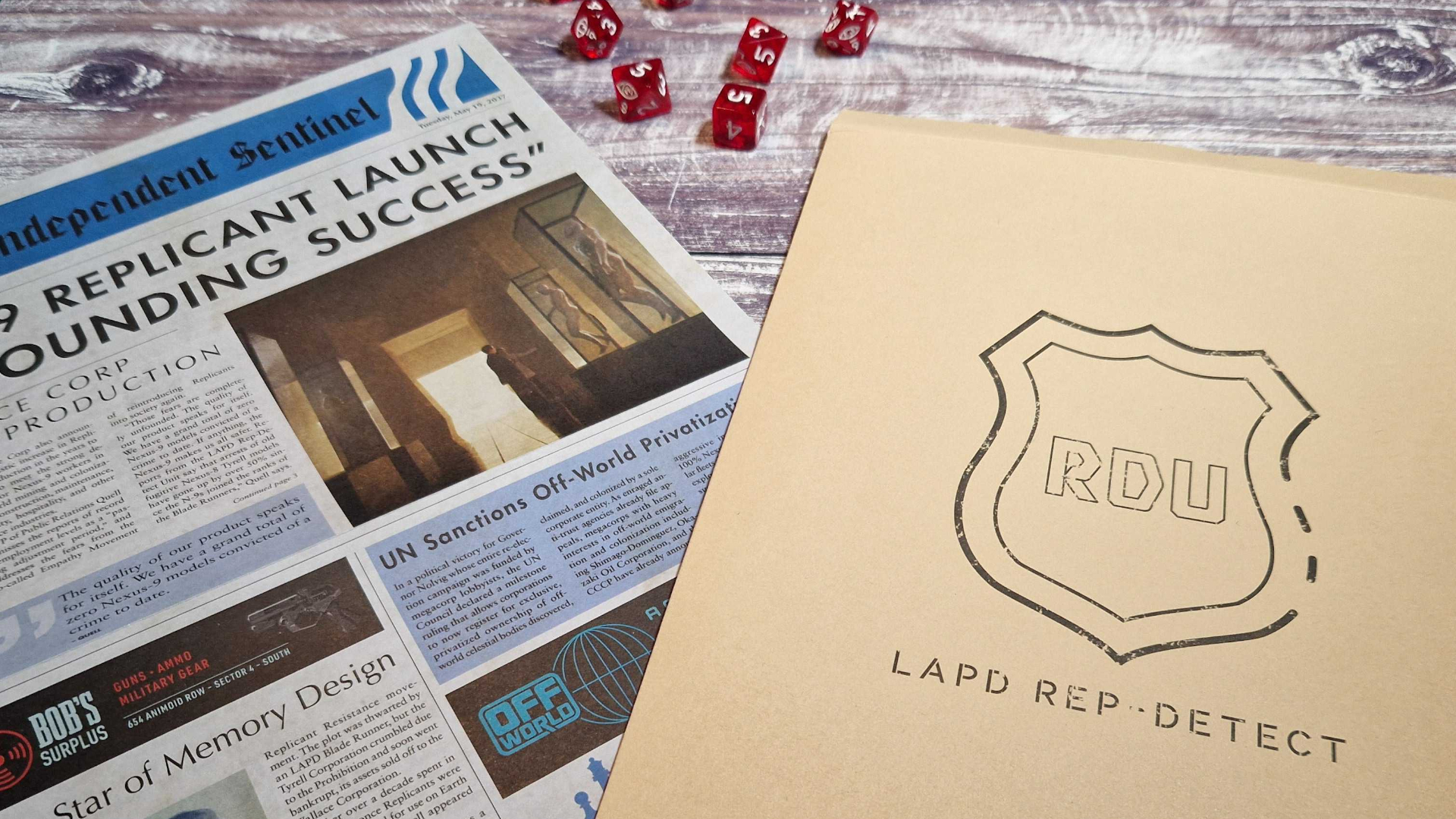 The evidence file and newspaper prop from the Blade Runner RPG on a wooden surface, along with some dice