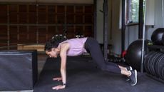 A woman performing burpees in the gym