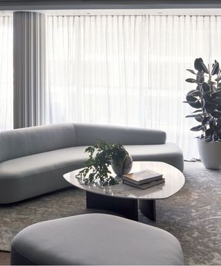 Grey curved sofa, textured carpet