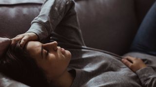 Close-up of stressed woman lying on sofa at home