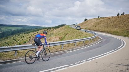 Male cyclist riding up a short climb