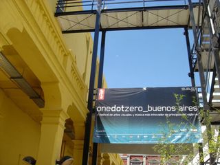 A banner for the visual festival is hung on a metal construction next to a building.