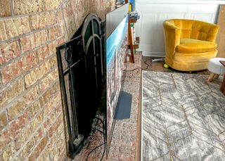 LG B2 OLED TV shown against a brick wall in a living room
