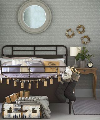 A vintage brown and grey bedroom with calligraphy wallpaper, wooden side table and storage trunk